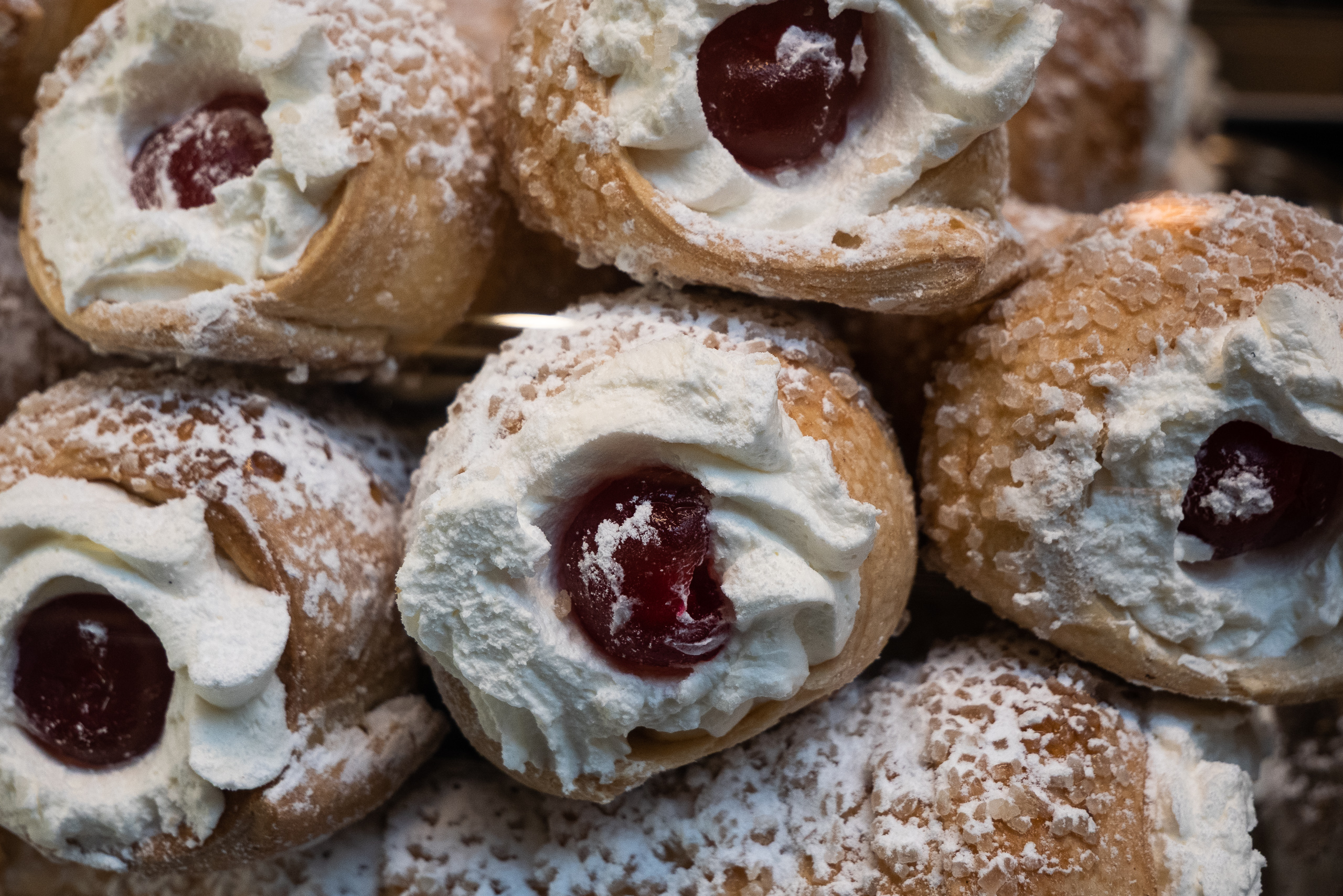 Sahnetörtchen mit kandierten Kirschen in der Auslage